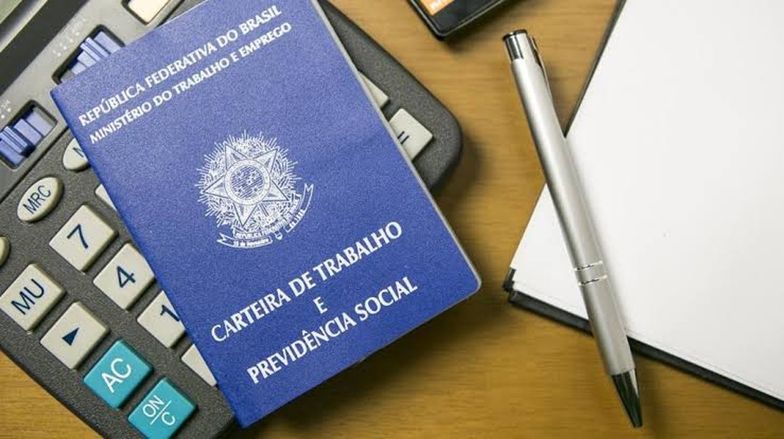 Carteira de Trabalho e Previdência Social sobre calculadora, ilustrando atualizações previdenciárias